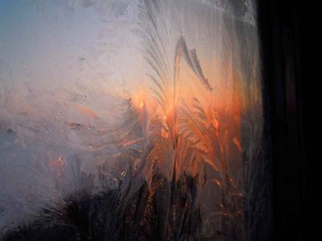 この写真は窓の外から撮ったのでしょう。朝焼け？と宇宙色の空が氷結した窓に映ってとてもきれいです。