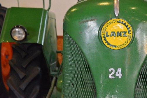 ランツブルドックトラクタ 1955年（昭和30）　ランツ社製（ドイツ） D-2416型　24馬力 1956年（昭和31）清里町　白戸雄策　導入 使用経過不明。 後年に野坂が入手、当時活躍していたことで自家保存のもの。 ランツ社とジョンディア社の業務提携時代の製品。  同型は3年間に道内に11台導入された。 LANZ BULLDOG TRACTOR YEAR: 1955(Showa 30) Manufacturer: Lanz(Germany)  In 1956(Showa 31)  this tractor was purchased dy Yuusaku Shirato of Kiyosato-machi. There is no record on hand of how the tractor was used at the time. After some years it came in to the hands of Mr. Nosaka, Who used it for spme time and then continued to preserve its condition at his home. This is one of the tractors that were a collaboration of the Lanz and John Deere companies.  Duaring the 3 years production of this model, 11 were purchased in Hokkaido.
