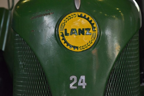 ランツブルドックトラクタ 1955年（昭和30）　ランツ社製（ドイツ） D-2416型　24馬力 1956年（昭和31）清里町　白戸雄策　導入 使用経過不明。 後年に野坂が入手、当時活躍していたことで自家保存のもの。 ランツ社とジョンディア社の業務提携時代の製品。  同型は3年間に道内に11台導入された。 LANZ BULLDOG TRACTOR YEAR: 1955(Showa 30) Manufacturer: Lanz(Germany)  In 1956(Showa 31)  this tractor was purchased dy Yuusaku Shirato of Kiyosato-machi. There is no record on hand of how the tractor was used at the time. After some years it came in to the hands of Mr. Nosaka, Who used it for spme time and then continued to preserve its condition at his home. This is one of the tractors that were a collaboration of the Lanz and John Deere companies.  Duaring the 3 years production of this model, 11 were purchased in Hokkaido.