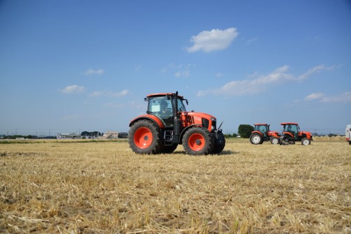 クボタトラクターM7001シリーズM7151です。広い麦の刈り跡にたくさんのクボタ製品が展示されています。試乗もできるようになっています。