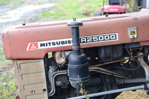 三菱トラクターR2500Gです。tractordata.comによれば、青いDトラの前の赤い三菱・・・1970年〜1975年製造。車体のプレートによると、1192cc2気筒ディーゼル25馬力/2700rpmです。