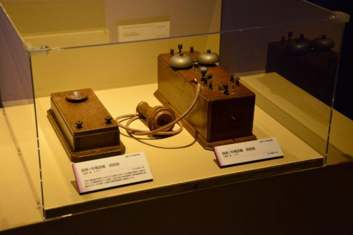 左：国産一号電話機　送話器　工部省製　レプリカ 日本に電話機が渡来したのは1877（明治10）年、ベルが電話を発明した翌年である。この電話機を使って工部省-工部大学校、東京電信局-横浜電信局で行くなわれ、その翌年、工部省の電信局製機所で国産化された。 右：国産第一号電話機　受話器 工部省製　レプリカ とあります。電話が発明された翌年日本に入ってくるとは・・・インターネットもない時代、色々なものがどんどん生まれるアメリカに、誰か貼付いて情報を取っていて、画期的なものがあればどんどん日本に持ってくるというシステムがあったに違いありません。