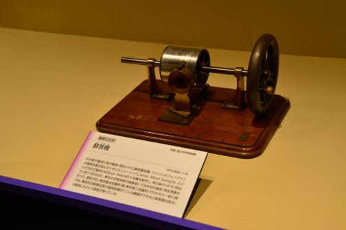 蘇言機（そごんき）1878（明治11）年 わが国で最初に音が録音・再生された錫箔蓄音機。エジソンのフォノグラフの発明を聞き及んだイギリス人ユーイング（James Alfred Ewing）は、エジンバラの工場MILNE&son MAKERSで本機を製作し、来日後の1878（明治11）年11月16日に、東京大学理学部の実験室にて日本初の録音・再生実験を行った。翌年3月に東京商法会議所（現・東京商工会議所）で行われた一般公開では、東京日日新聞社長の福地桜痴が「こんな機械ができると新聞屋は困る」と録音したという逸話が残っている。 とあります。機械の名前がおもしろいですね。蘇言機（そごんき）蘇ることばですものね！
