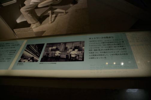 そのお隣には座席予約システム、マルスの中央処理質の写真とともにキャプションが続きます。 ネットワームの始まり 1960年になると、コンピュータはオンラインシステムとして銀行や証券取引所などに導入されて行った。1964（昭和39）年の東京オリンピックでは、データの集計に威力を発揮し、同年、国鉄（現JR）の座席予約システムの運用も始まった。その後のコンピュータ・システムの発展は目覚ましく、いまや私たちの生活の根幹となっている。 とあります。