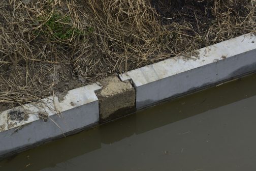 こういうのを柵渠（さっきょ）というらしいですね。柵渠とは、柵状の製品等を使用して造られた水路をいうということです。で、そのコンクリートの板だけ交換するので、このように支柱は古いままです。