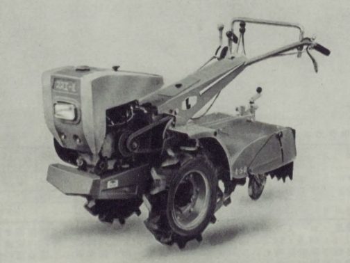 写真を拡大します。エンジンやハンドル根本部分に大きめの四角いカバーをただ掛けたような形。「初めの頃感」がプンプンします。おでこに大きく「スズエ-L」と書かれていますし大きく無骨なハンドルネックのカバーにもでっかく「L」と書かれているのがわかります。