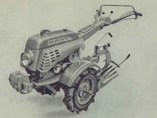 耕運機部分だけ拡大します。当時の耕運機としては珍しい逆スラントのカバーが掛かっています。デザイン性の高い「タカキタ」の文字、そして先頭にはおそらくカバーを外すためのハンドルとオーナメントを兼ね備えたような大きめのマーカーが付いています。他のメーカーに対してデザインで違いを作る意図が強く感じられます。しかし、この耕運機に限らず少なくとも1961年認定の耕運機は全てと言っていいほどカバーが掛かっています。考えてみると、カバーが掛かっていないとシバウラや三菱、せいぜいロビンなどエンジンの種類は耕運機のメーカーよりずっと少なかったですからバットみどこの製品かわかりません。こんなカバーでも掛けていないと見分けがつかなかったのでしょう。