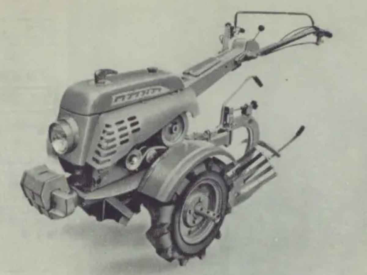 耕運機部分だけ拡大します。当時の耕運機としては珍しい逆スラントのカバーが掛かっています。デザイン性の高い「タカキタ」の文字、そして先頭にはおそらくカバーを外すためのハンドルとオーナメントを兼ね備えたような大きめのマーカーが付いています。他のメーカーに対してデザインで違いを作る意図が強く感じられます。しかし、この耕運機に限らず少なくとも1961年認定の耕運機は全てと言っていいほどカバーが掛かっています。考えてみると、カバーが掛かっていないとシバウラや三菱、せいぜいロビンなどエンジンの種類は耕運機のメーカーよりずっと少なかったですからバットみどこの製品かわかりません。こんなカバーでも掛けていないと見分けがつかなかったのでしょう。